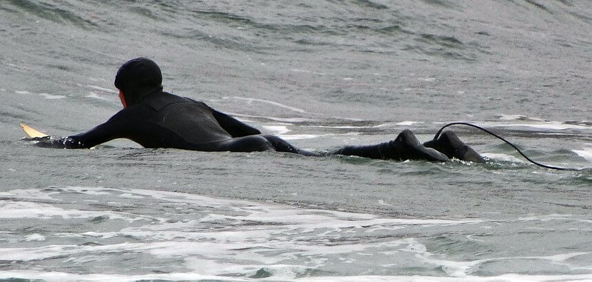 Surfer mit Haube und Booties