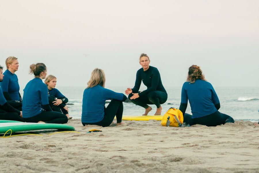 Surflehrerin Julia gibt im Anfänger-Surfkurs von Goodtimes am Surfstrand von Gelfa eine Einführung zum Thema Sicherheit beim Surfen