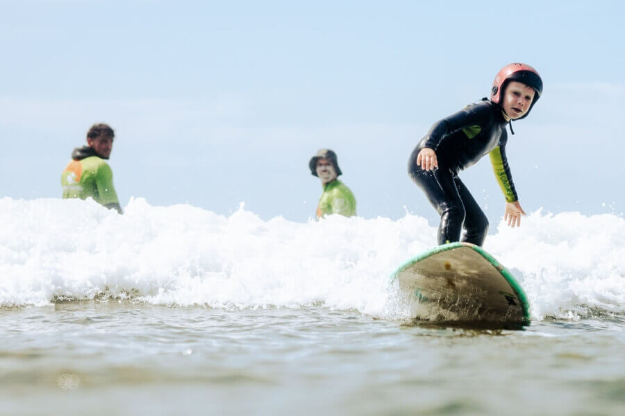 Kind mit Helm im  Surfkurs der Surfschule 3Ondas in Ericeira bei Lissabon